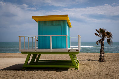 Lifeguard hut on beach against sky