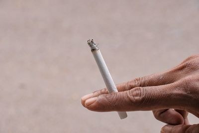 Close-up of hand holding cigarette