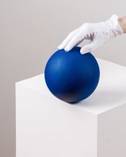 Close-up of blue ball on table against wall