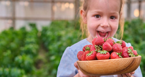 Portrait of cute girl holding strawberries