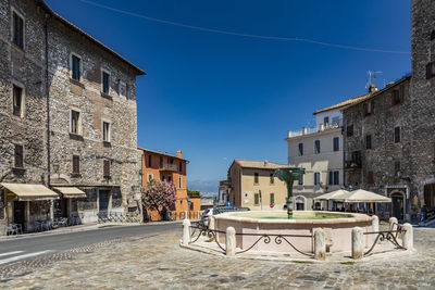 Street and buildings against blue sky