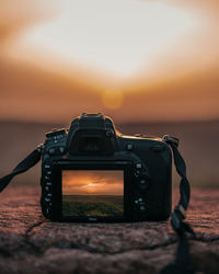 Close-up of camera on beach during sunset