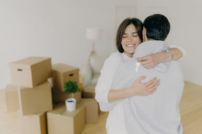 Couple embracing while standing in new house