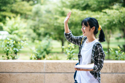 Full length of woman standing against plants