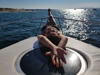 Woman lying on boat in sea