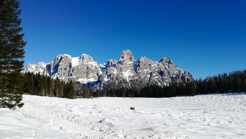 Scenic view of snowcapped mountains against clear blue sky