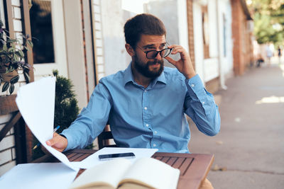 Businessman looking away while sitting at outdoors cafe