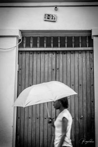 Rear view of woman with umbrella walking in rain