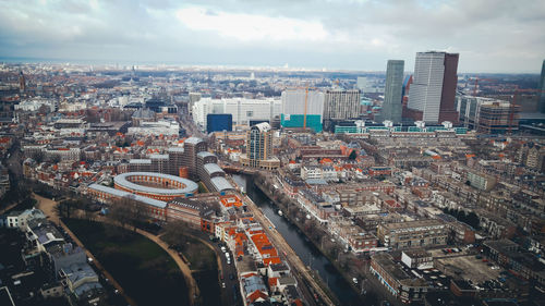 High angle view of city lit up against cloudy sky