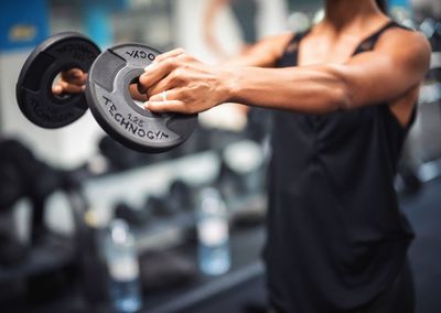 Midsection of young man exercising in gym