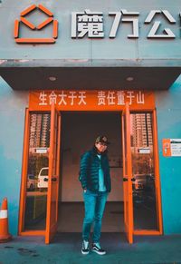 Full length of woman standing against building