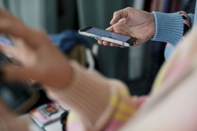 Cropped image of female owners using smart phone in boutique