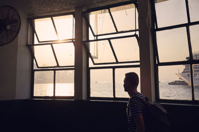 Man looking through window