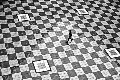 High angle view of woman walking on checked floor