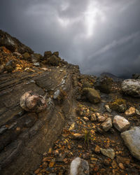 Rock formation on shore against sky