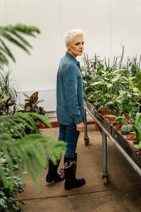 Woman gardener busy in greenhouse or flower shop. plant care hobby.