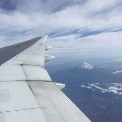 Airplane flying over snowcapped mountains against sky