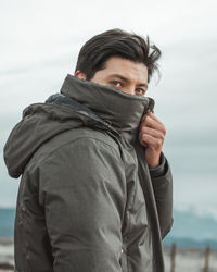 Portrait of young man covering his face