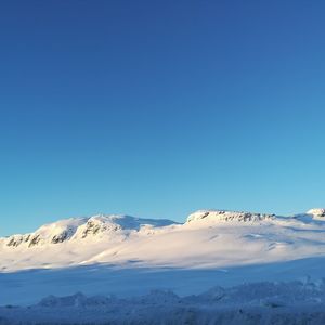 Scenic view of snowcapped mountains against clear blue sky