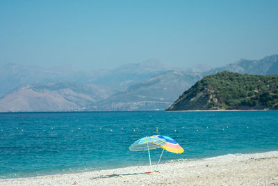 Scenic view of sea by mountains against sky