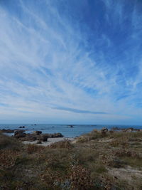 Scenic view of beach against cloudy sky