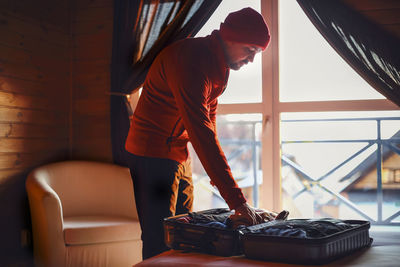 Young man using laptop while sitting on sofa at home
