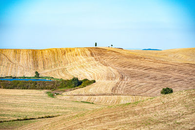 Hay bales on field against sky