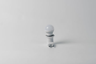 Close-up of light bulb against white background