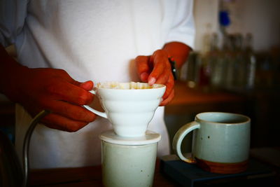 Midsection of coffee cup on table