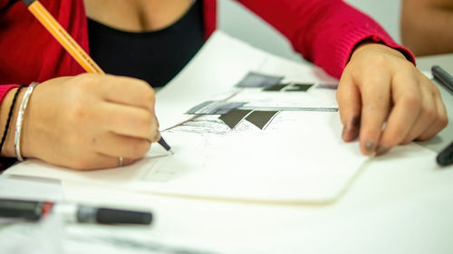 Person drawing by hand with pen, pencil and ink, architectural perspectives, in color.