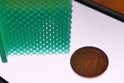 Low angle view of multi colored pencils on table against wall