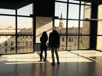 Rear view of silhouette people walking in building