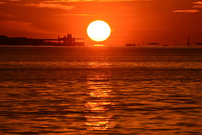 Scenic view of sea against orange sky