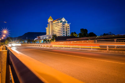 Light trails on street against buildings at night