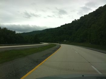 Road leading towards mountains against sky