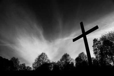 Low angle view of silhouette cross against sky