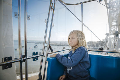 Full length of boy looking through boat window