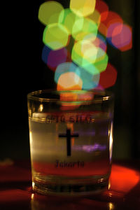 Close-up of lit candle against black background