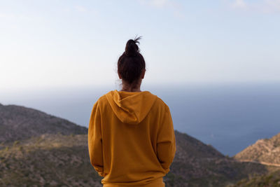 Rear view of man looking at mountain against sky