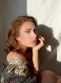 Portrait of young woman sitting on bed at home