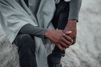 Midsection of man with hands standing outdoors