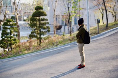 Rear view of man walking on road in city