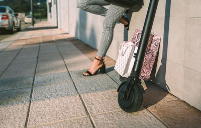 Low section of woman standing on footpath