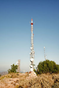 Low angle view of communications tower against clear blue sky