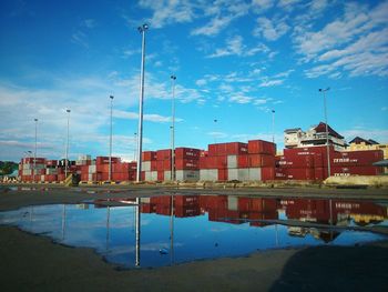 Reflection of buildings in lake against blue sky