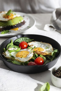 Breakfast with fried eggs and vegetables in a pan