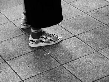 Low section of man standing on tiled floor