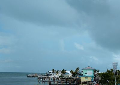 Buildings by sea against sky