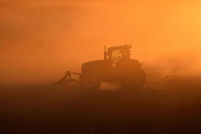 Silhouette of person on field against sky during sunset