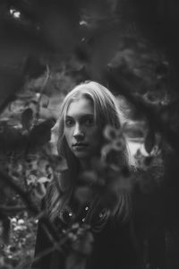 Portrait of young woman looking at tree